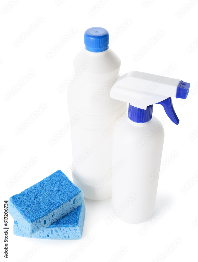 Bottles of detergent and blue cleaning sponges on white background