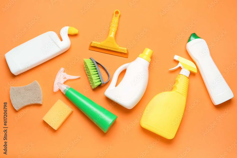 Different cleaning supplies on orange background