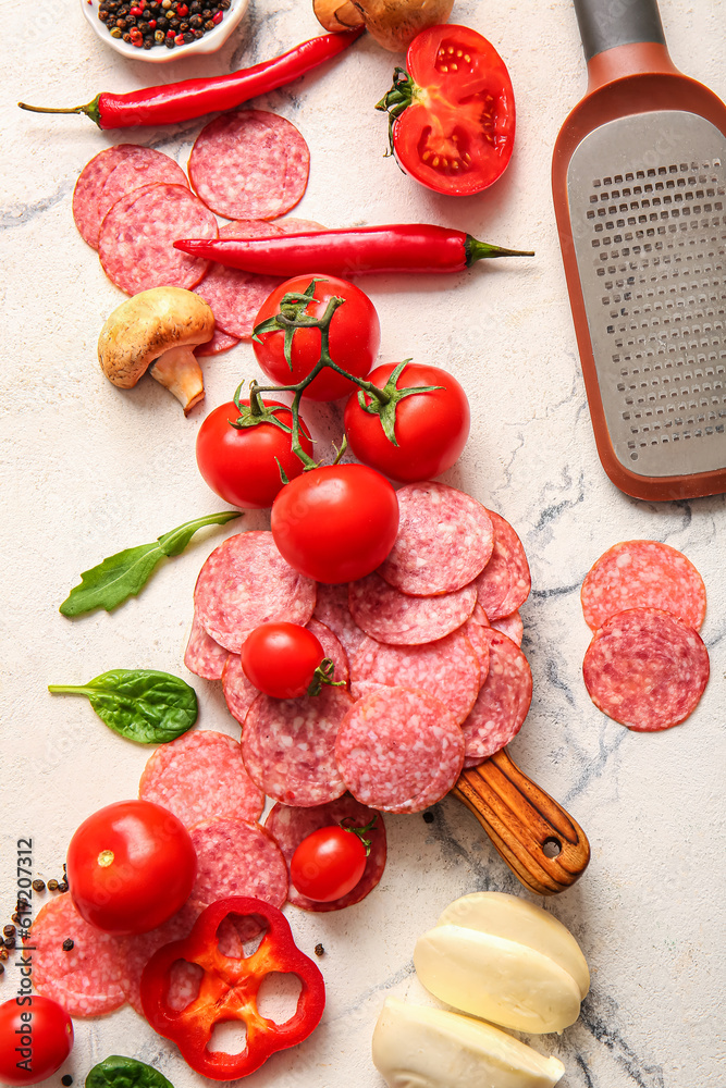 Different ingredients for preparing pizza on white marble background