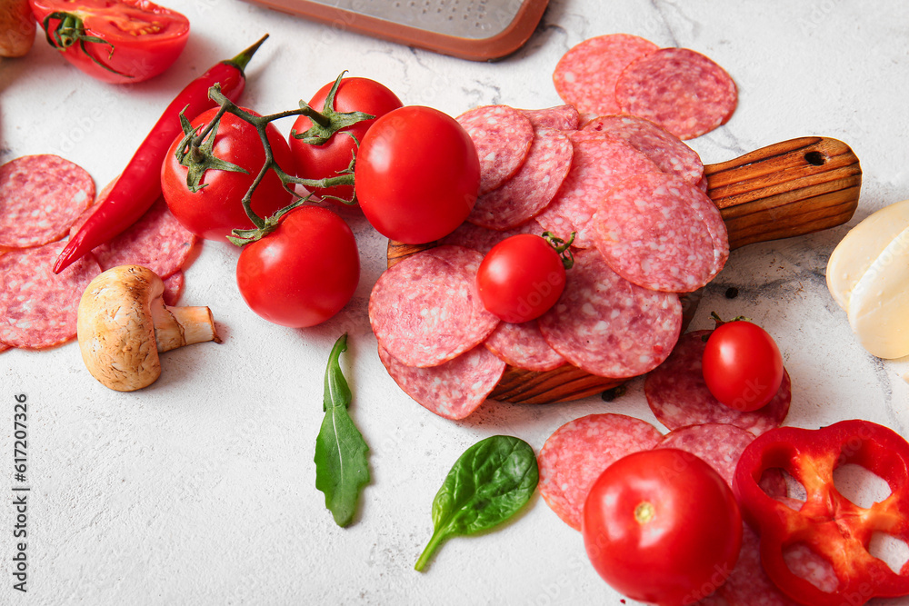 Different ingredients for preparing pizza on white marble background