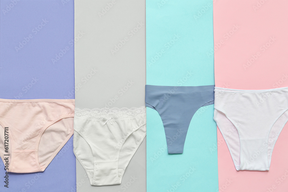 Set of different female panties on color background