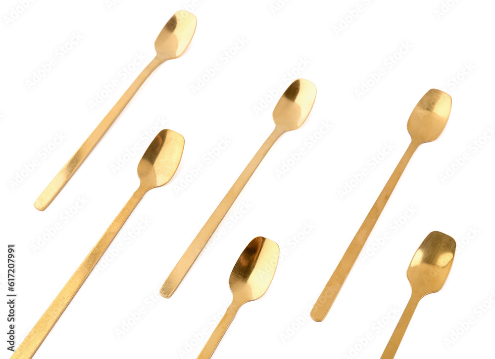 Golden spoons on white background