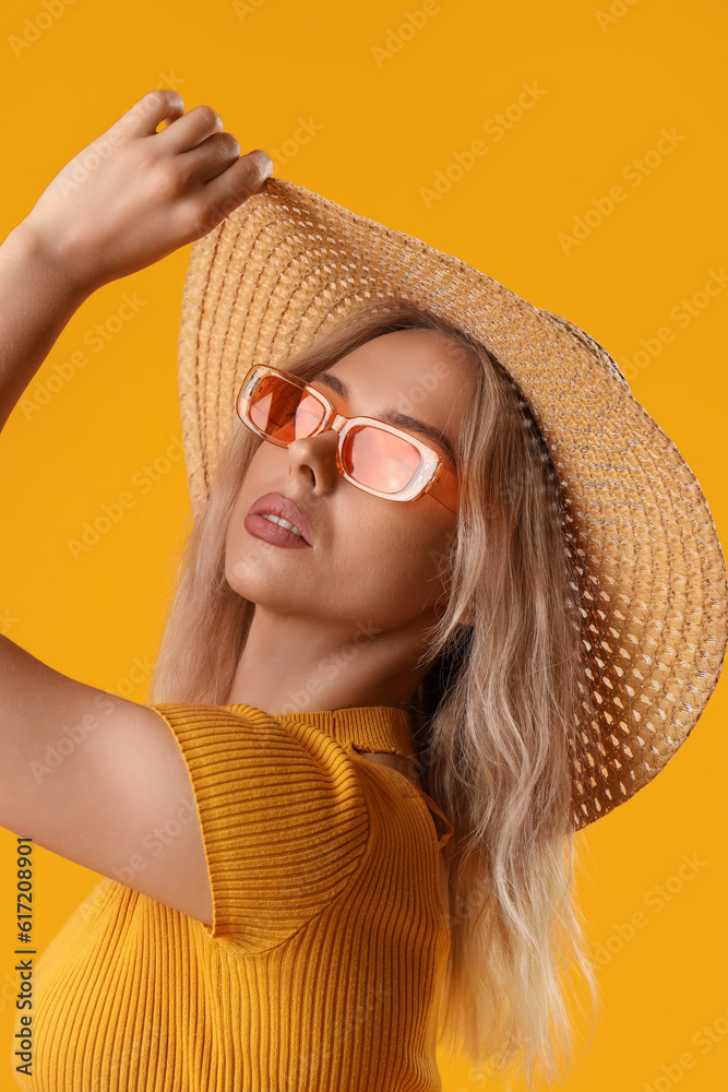 Young woman in stylish sunglasses on orange background, closeup