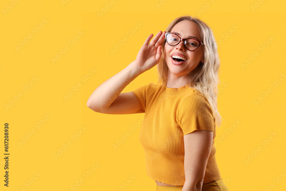 Happy young woman in stylish eyeglasses on orange background