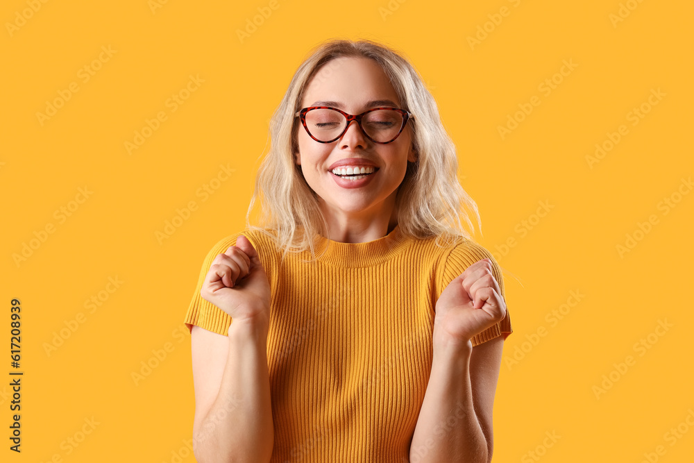 Happy young woman in stylish eyeglasses on orange background