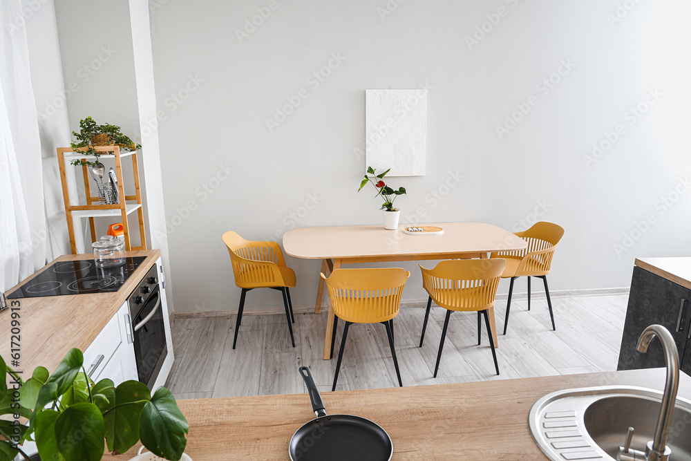 Interior of modern kitchen with wooden countertops and dining table