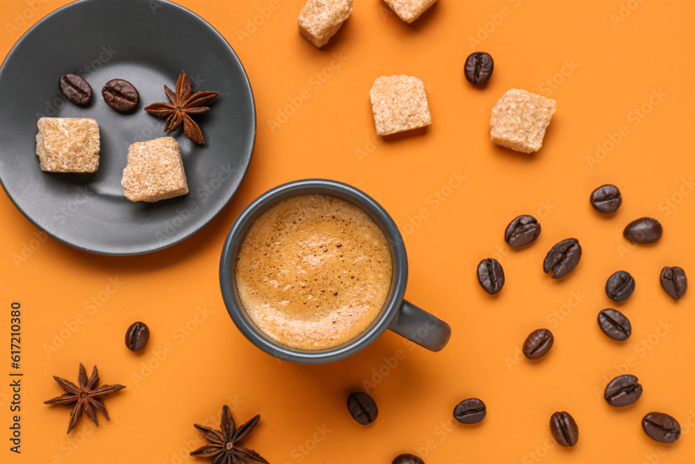 Cup of hot espresso, sugar and coffee beans on orange background