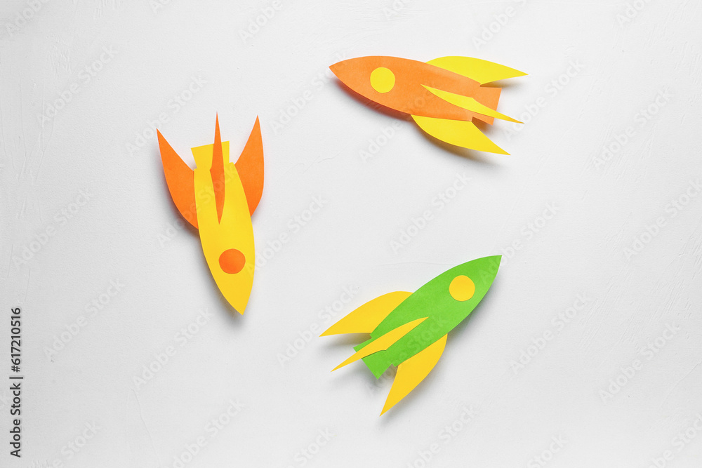 Color paper rockets on white background