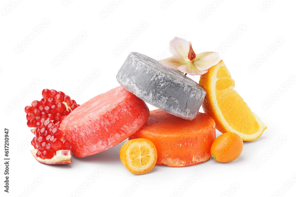 Colorful solid shampoo bars with flower, orange and pomegranate on white background