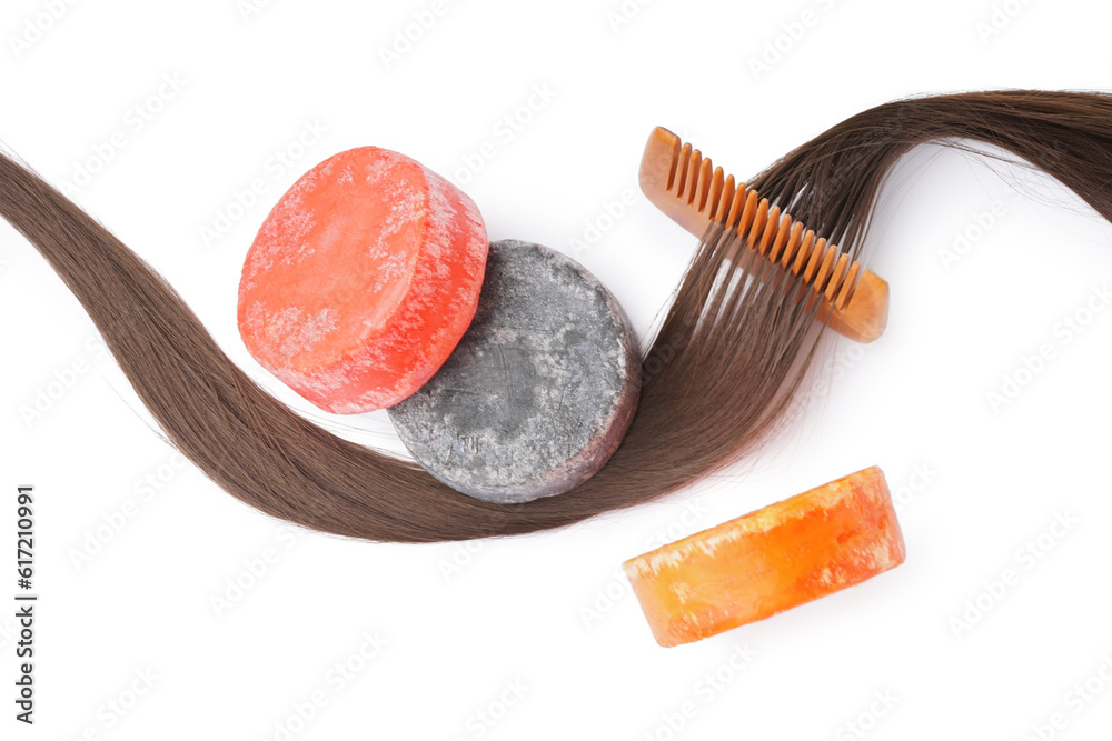 Colorful solid shampoo bars with hair and comb on white background