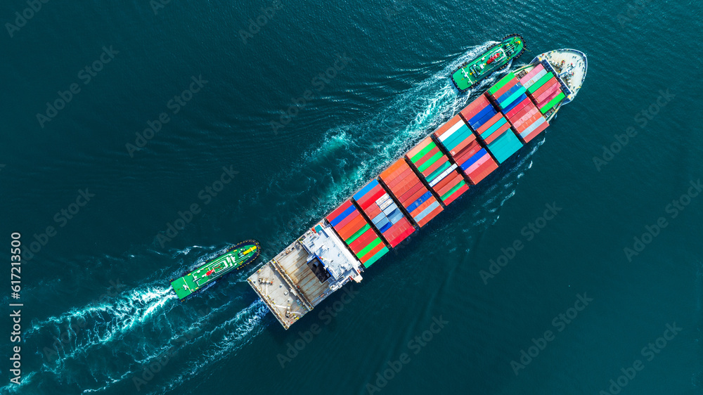 Aerial top view of cargo ship carrying container and running with tug boat for import export goods f