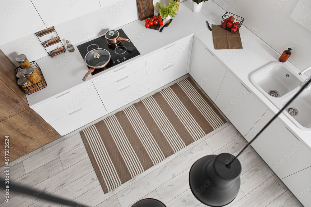 Stylish striped rug in interior of modern kitchen