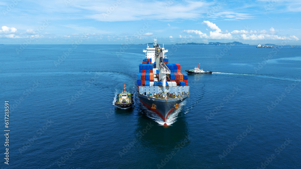 Aerial front view of cargo ship carrying container and running with tug boat for import export goods