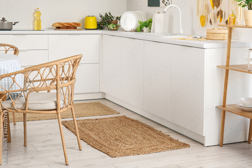 Stylish wicker rugs in interior of modern kitchen