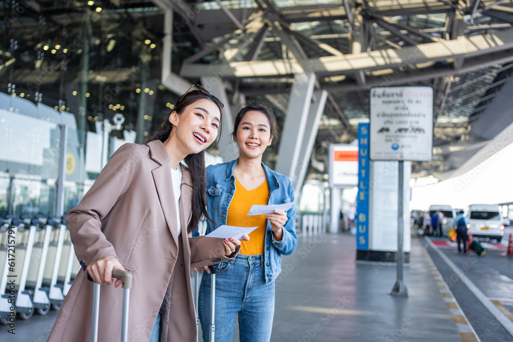 Asian two women passenger waiting a bus after leaving from the airport. 