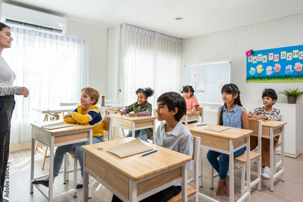 Group of student learn with teacher in classroom at elementary school. 