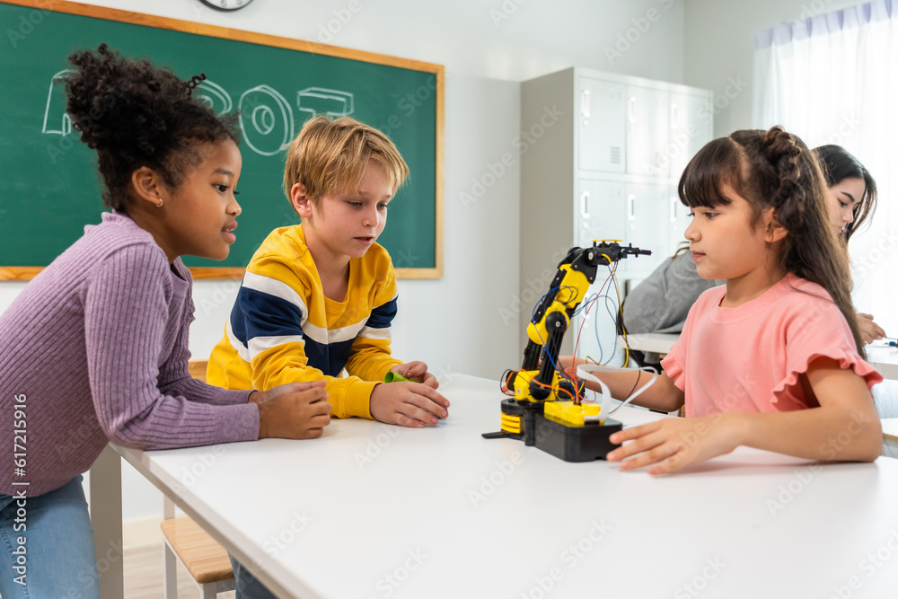 Adorable student learn with teacher in classroom at elementary school. 