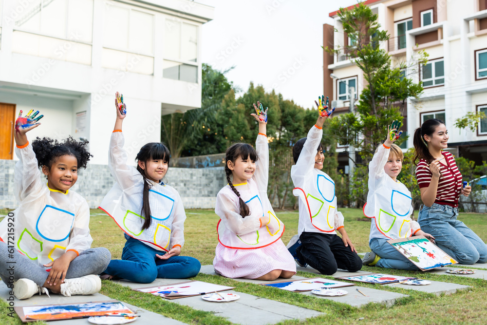 Group of student coloring on painting board outdoors in school garden. 