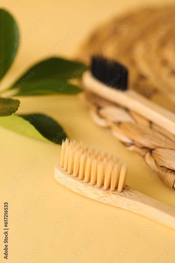 Bamboo tooth brushes on beige background, closeup