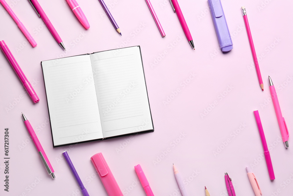 Notebook with different school stationery on lilac background