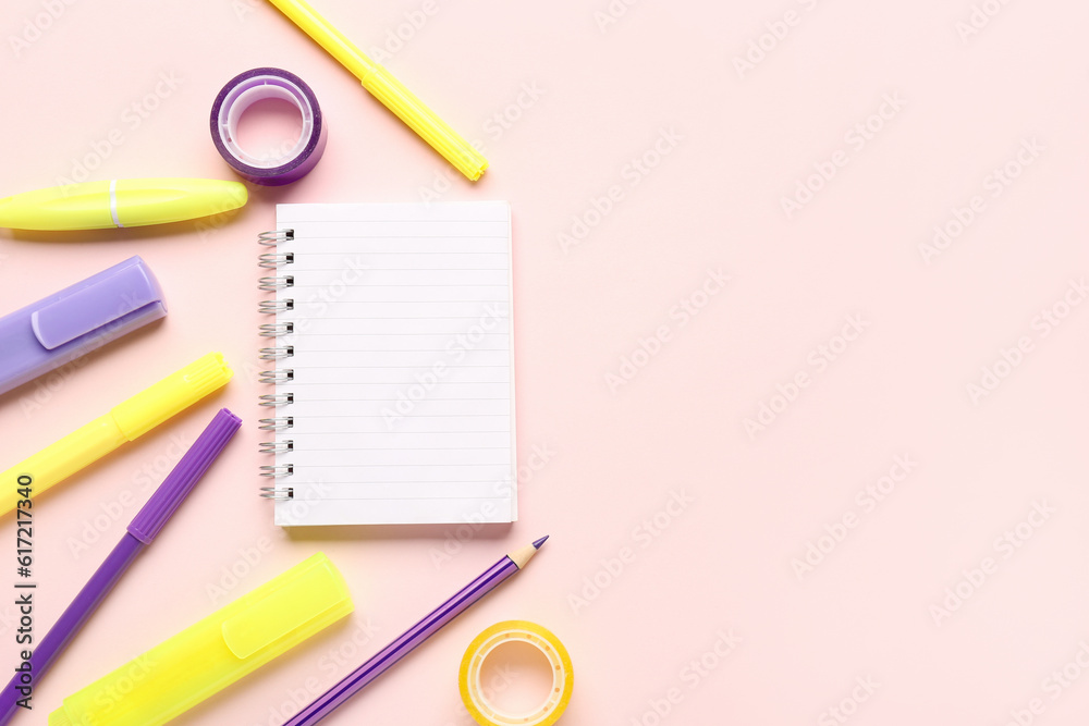 Notebook with different school stationery on pink background