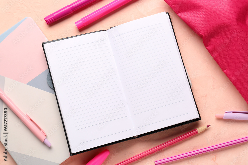 Notebooks with pencil case and different stationery on pink background