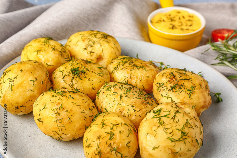 Plate of boiled baby potatoes with dill and sauce, closeup