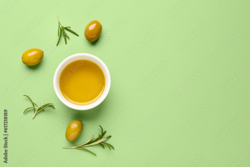 Bowl with fresh olive oil on green background