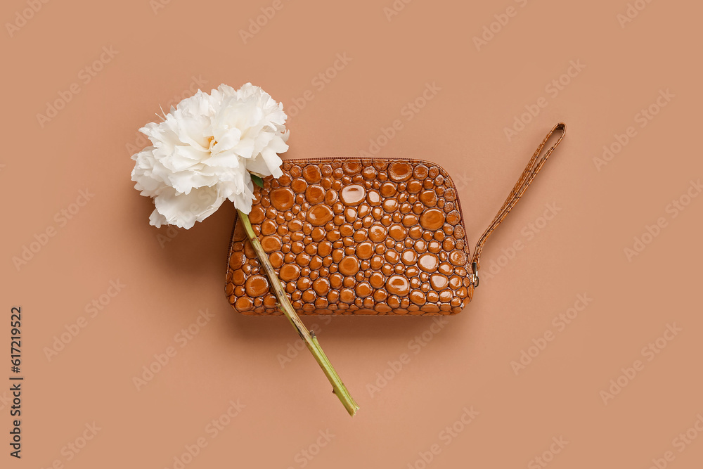 Stylish cosmetic bag with beautiful peony flower on color background