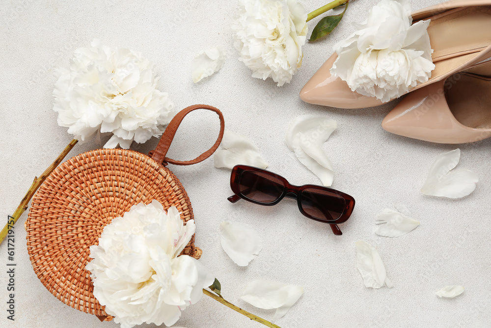 Composition with female sunglasses, bag, high heels and beautiful peony flowers on light background