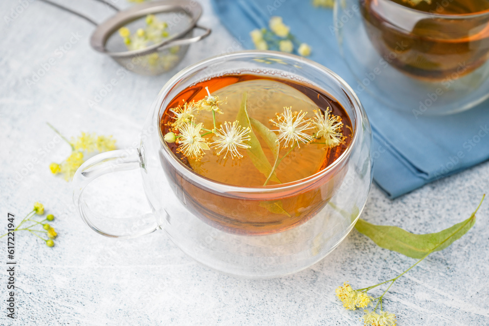 Glass cup of linden tea on white background