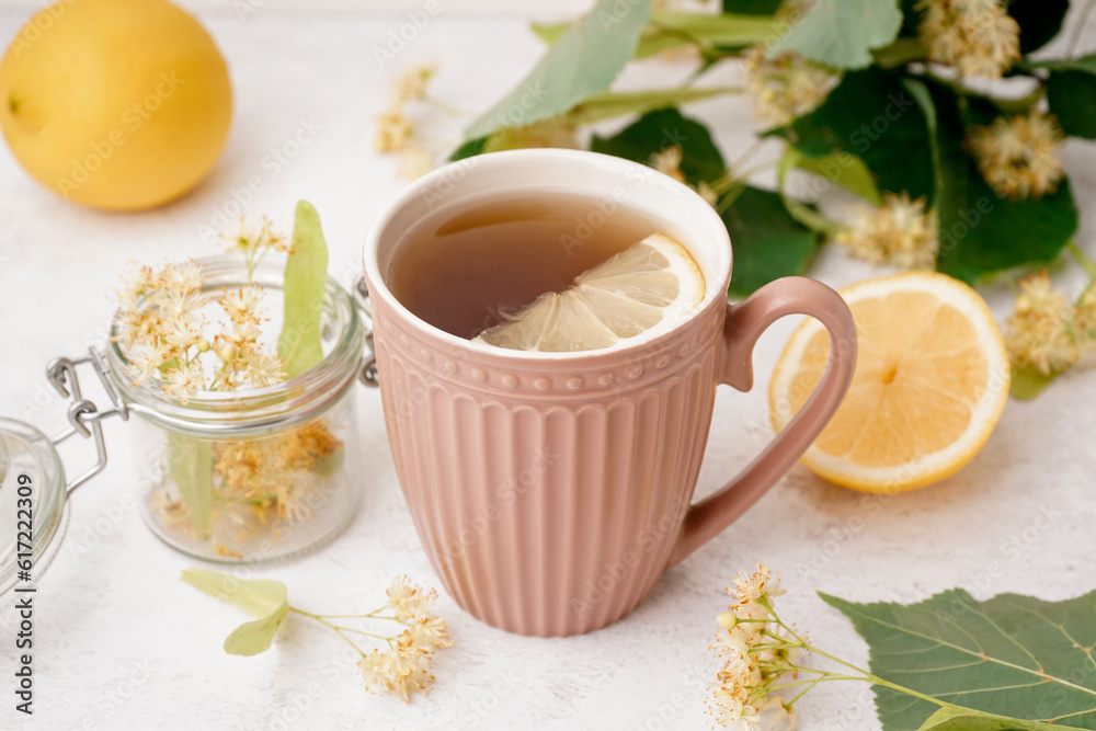 Cup of linden tea with lemon on white background