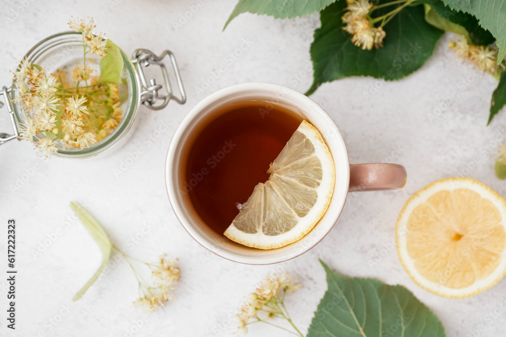 Cup of linden tea with lemon on white background