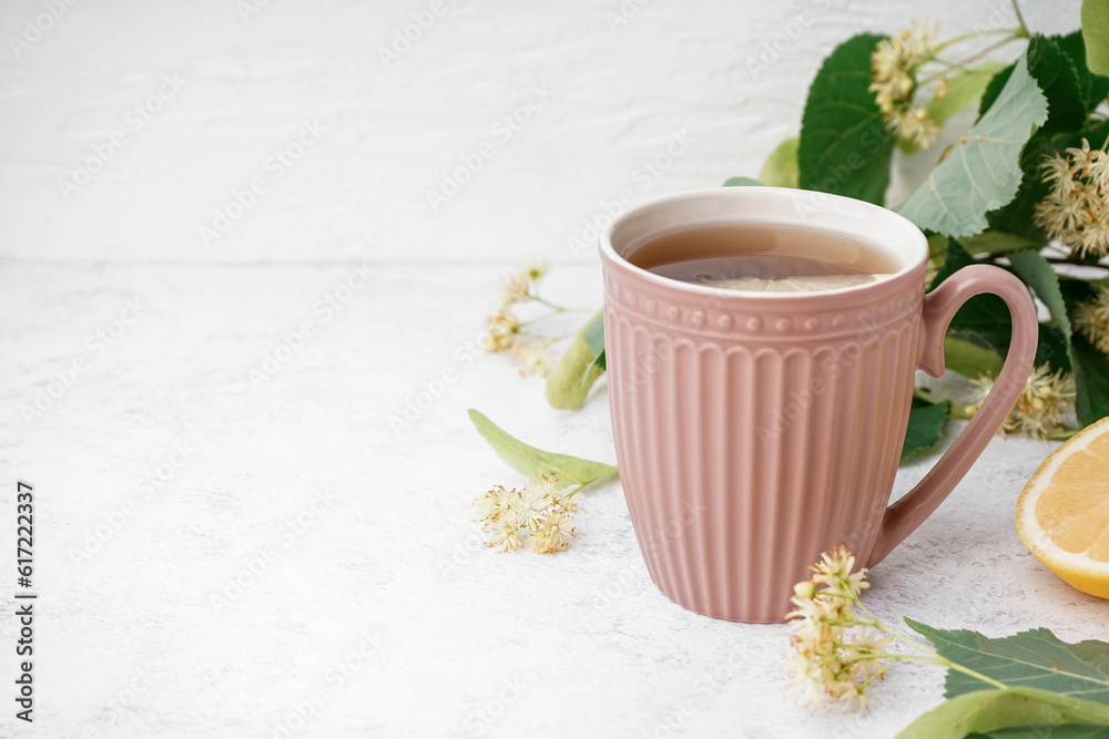 Cup of linden tea with lemon on white background