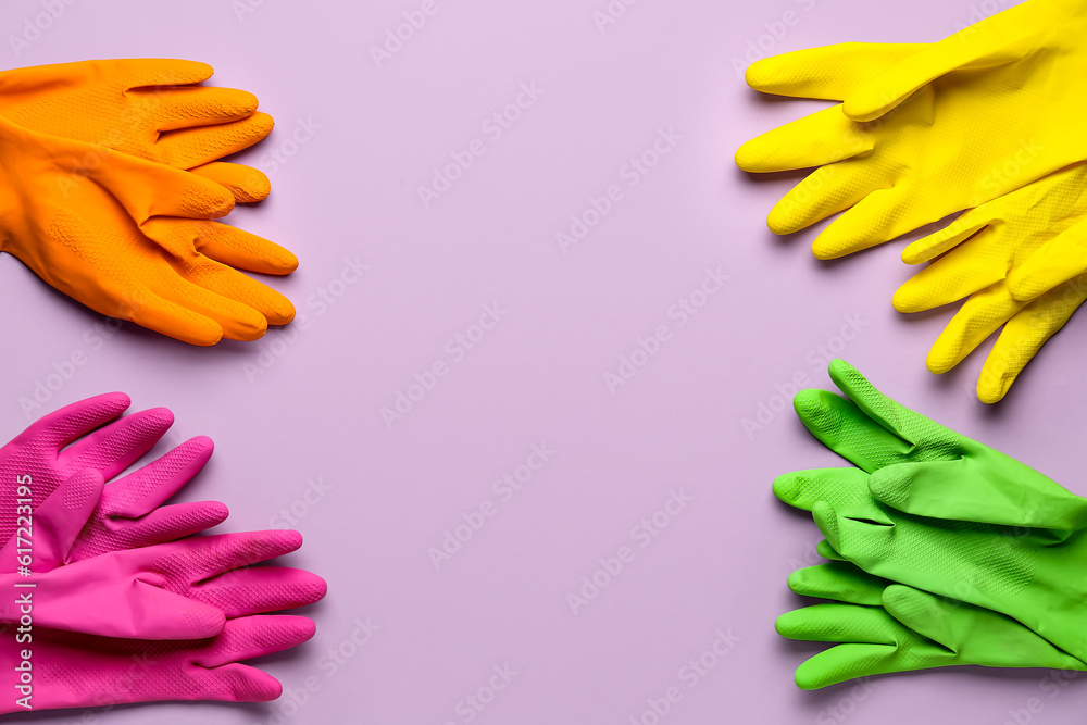 Frame made of colorful rubber gloves on lilac background