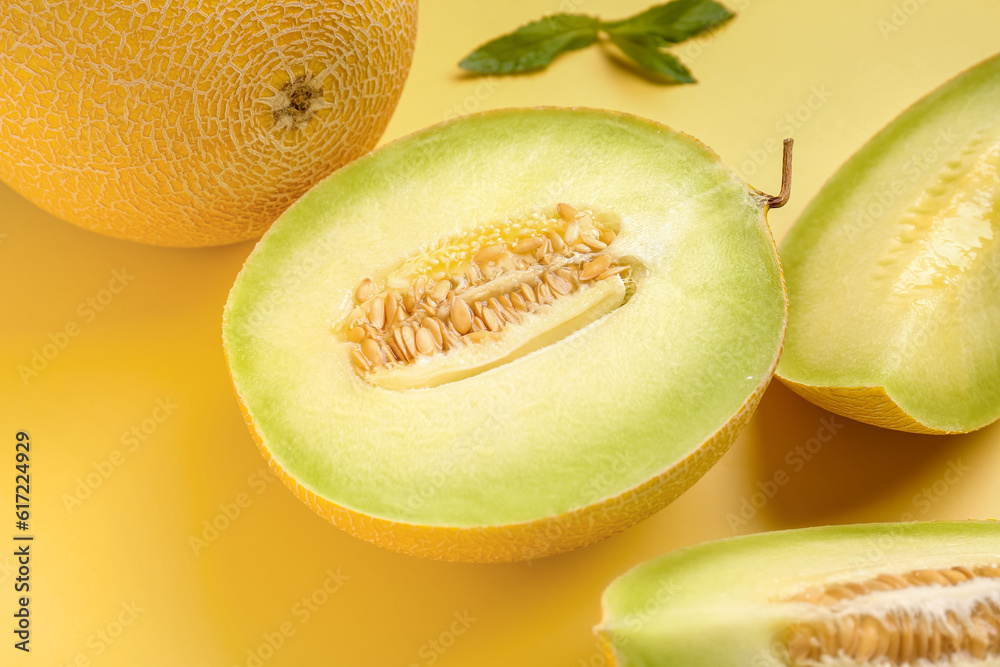 Sweet melon with pieces and mint on yellow background