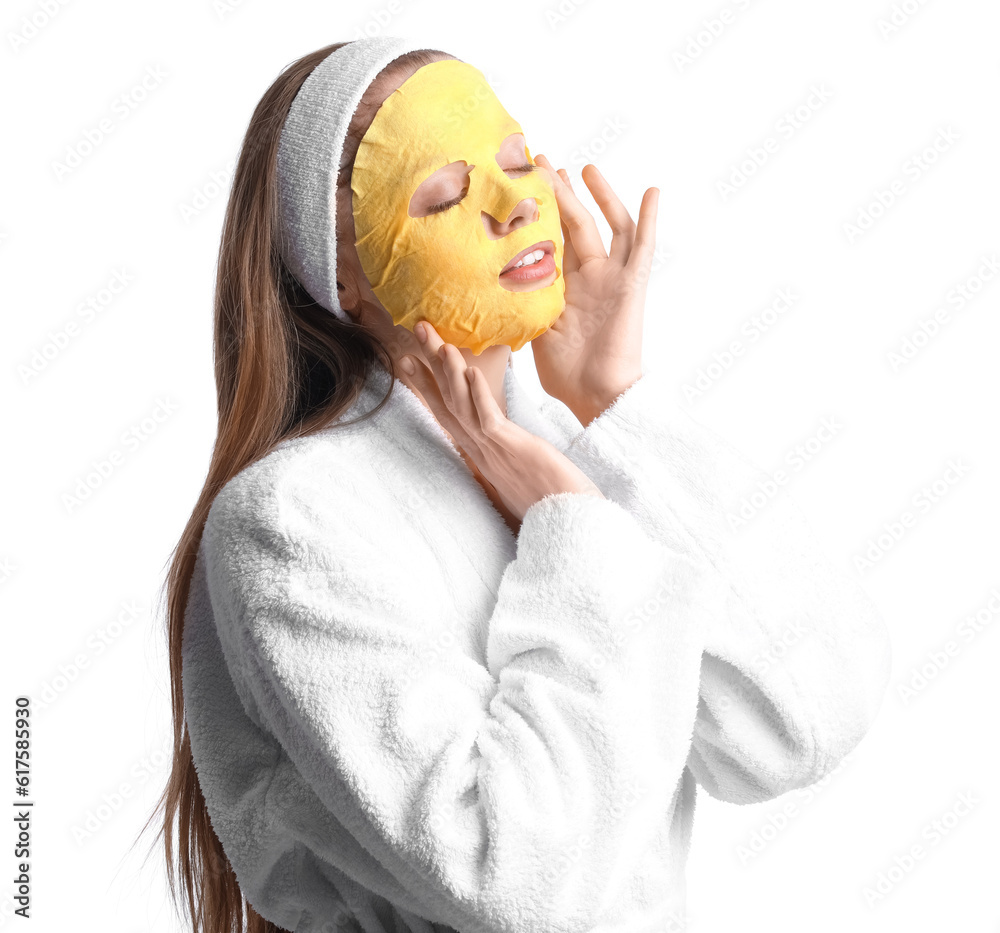 Young woman in bathrobe with turmeric mask on white background