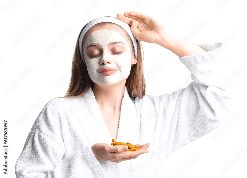 Young woman with applied turmeric mask and roots on white background