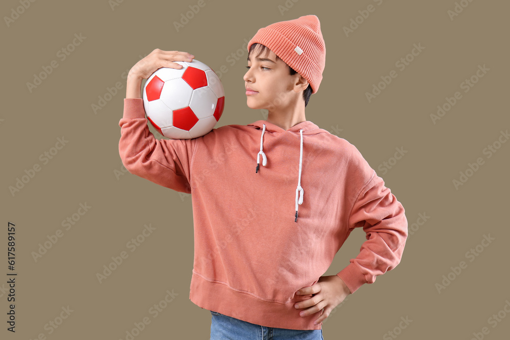 Little boy with soccer ball on color background