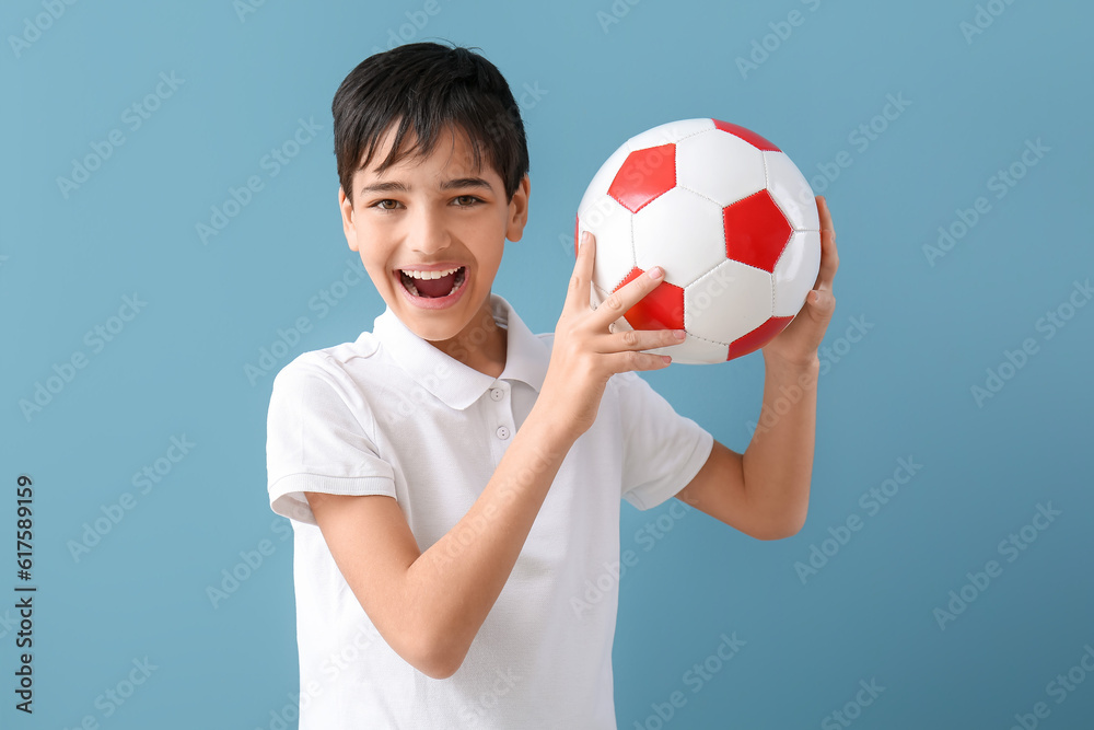 Little boy with soccer ball on blue background