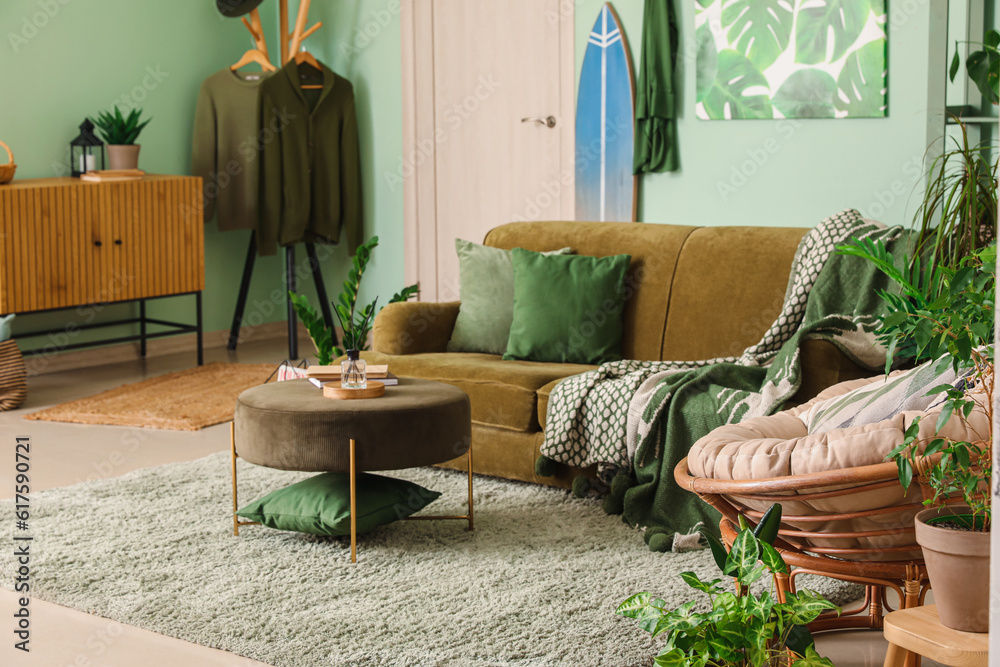 Interior of stylish living room with surfboard, sofa and armchair