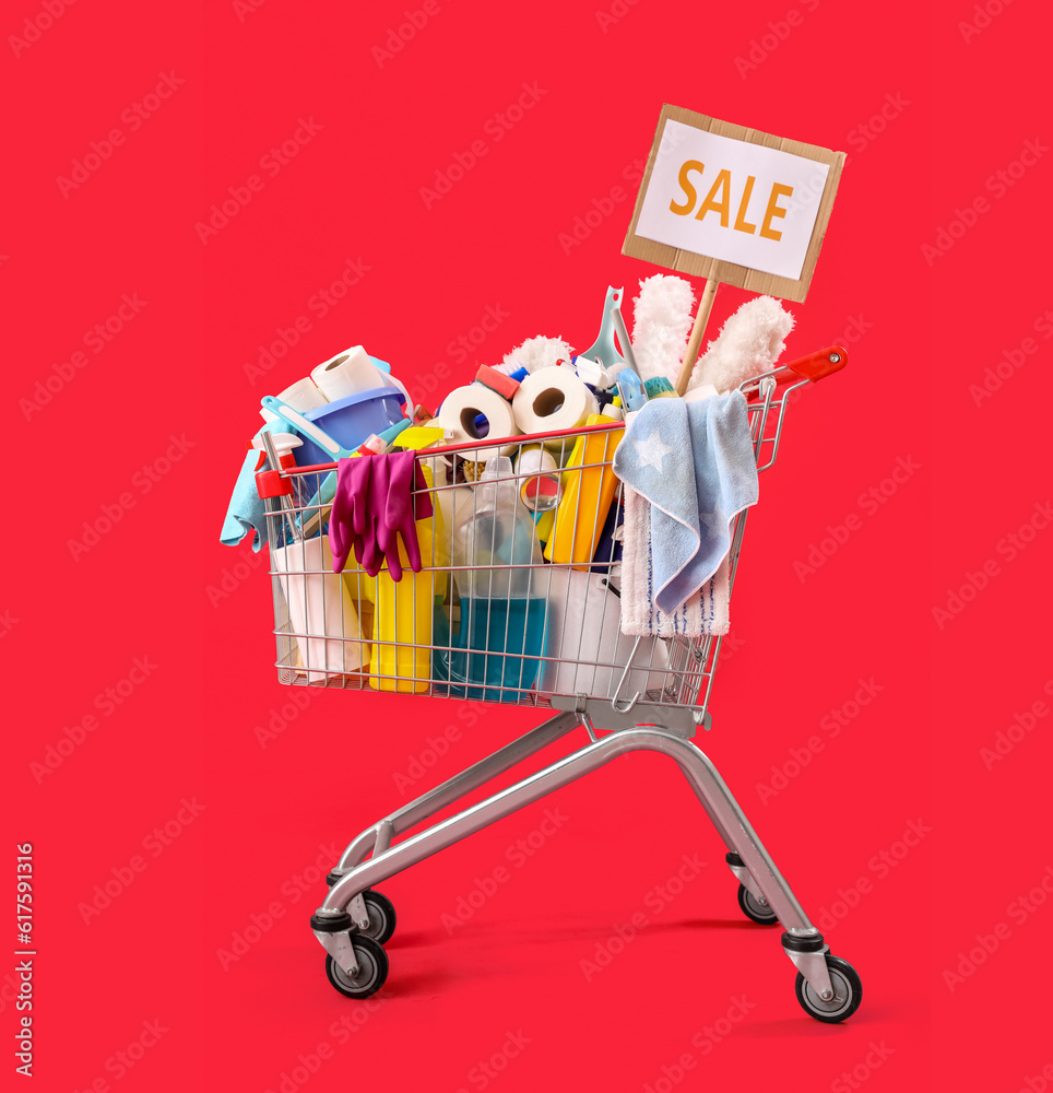 Shopping cart full of cleaning supplies with word SALE on red background