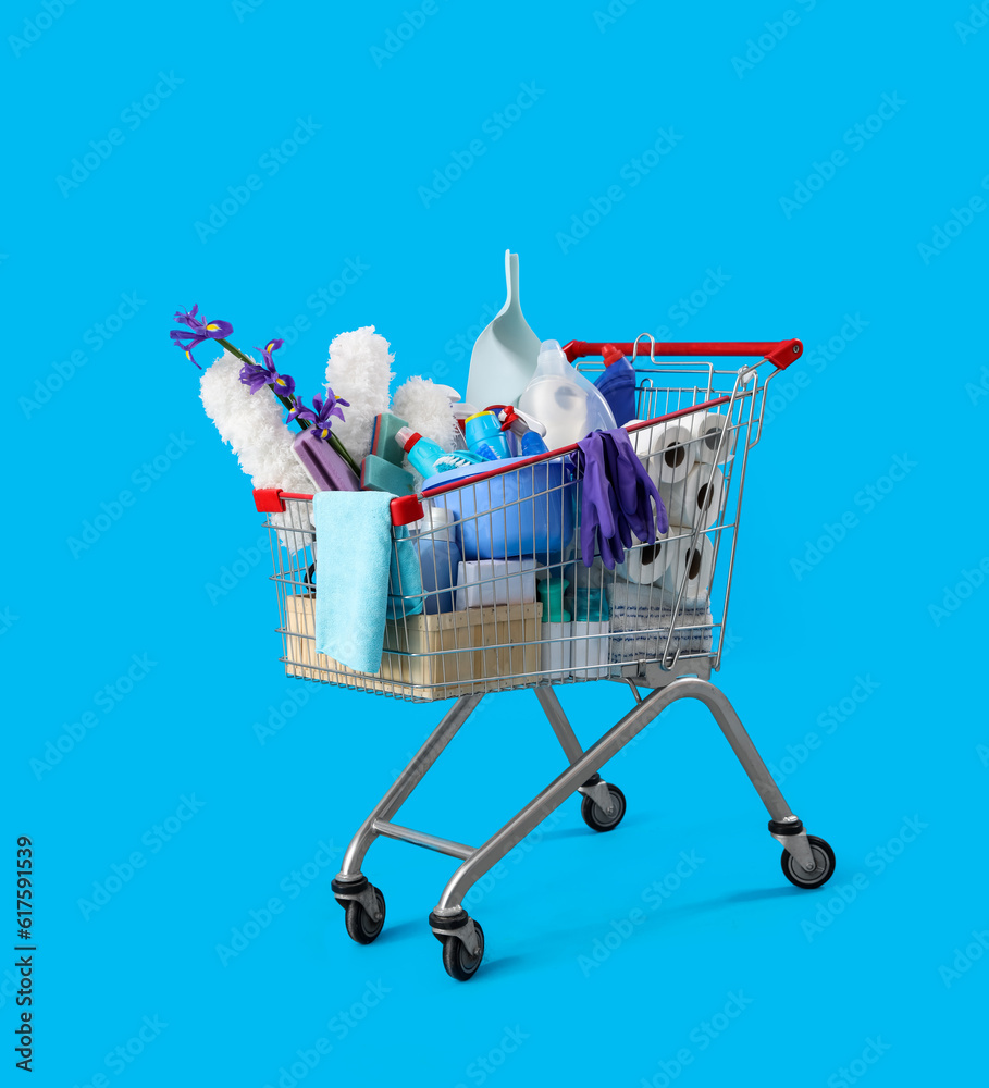 Shopping cart full of cleaning supplies and purple flowers on blue background