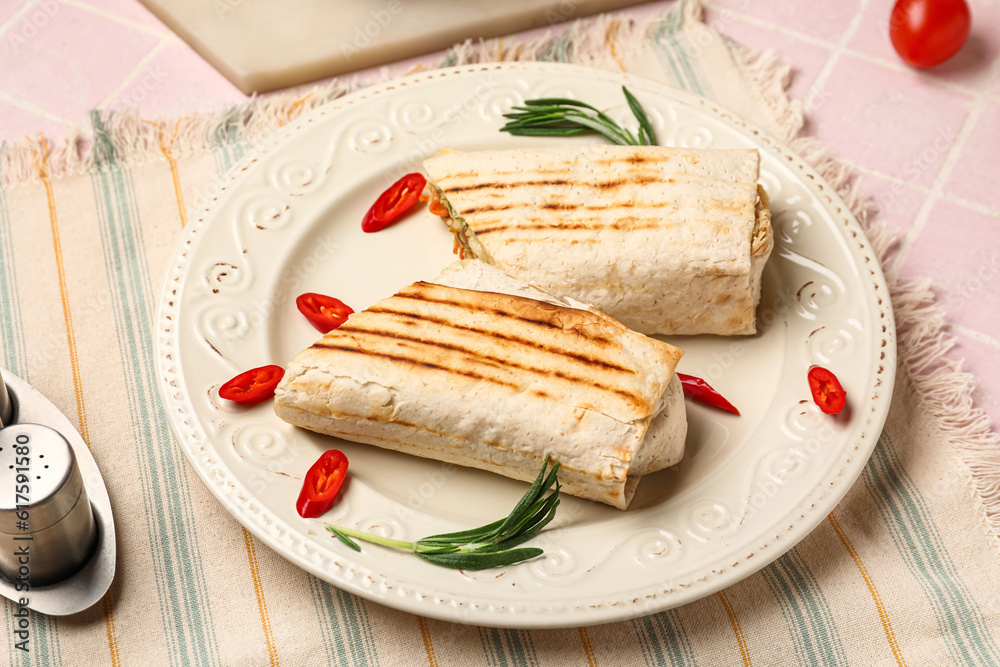 Plate with tasty shawarma and chilli on pink tile table