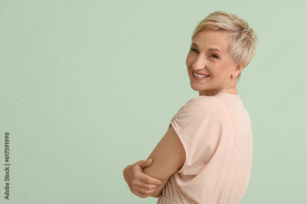 Mature blonde woman on green background