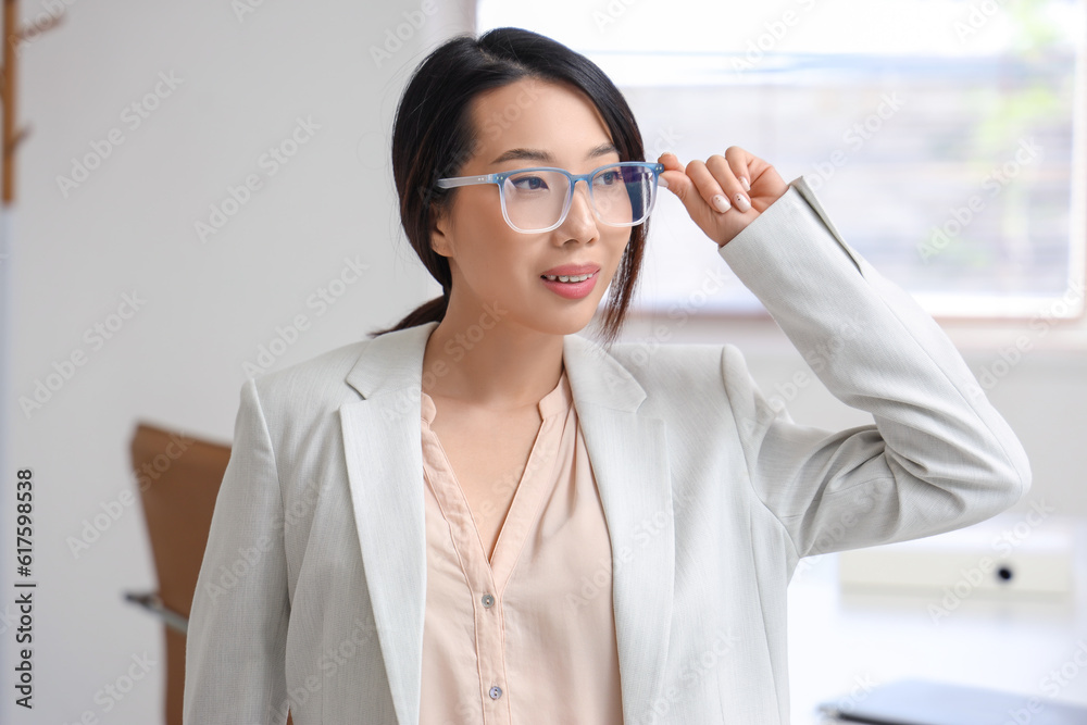 Beautiful Asian businesswoman in stylish eyeglasses in office