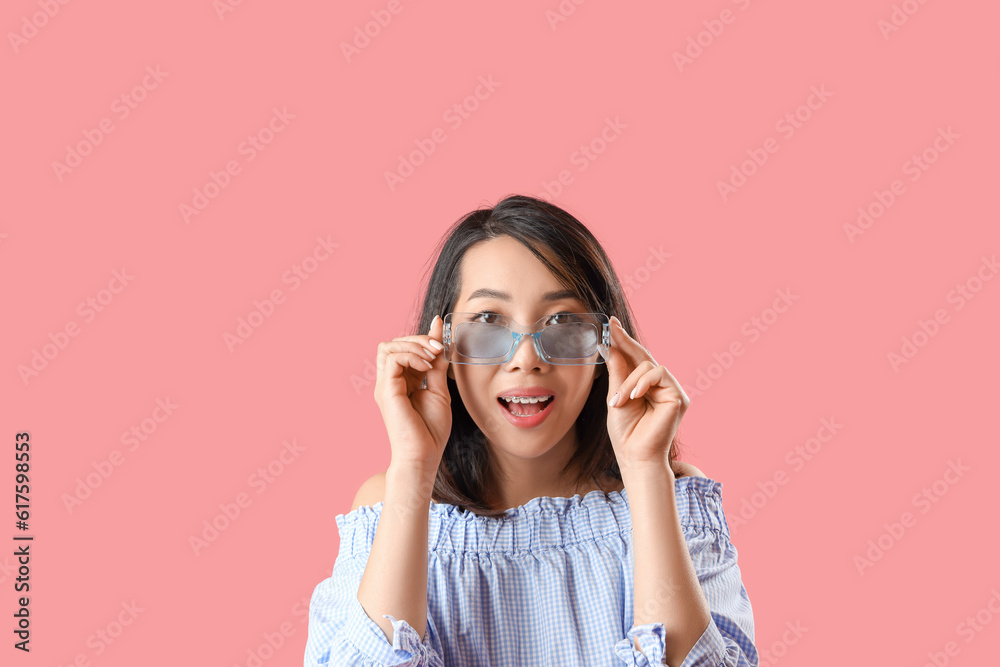 Beautiful Asian woman in stylish sunglasses on pink background