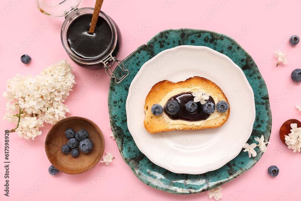 Composition with blueberry jam, toast and flowers on pink background