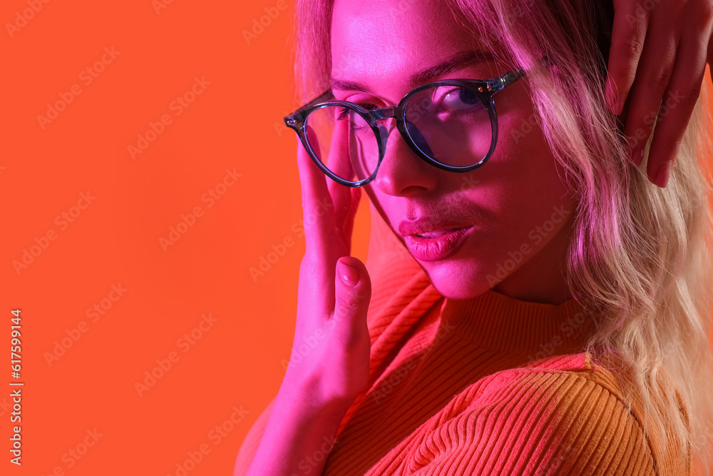 Young woman in stylish eyeglasses on color background, closeup