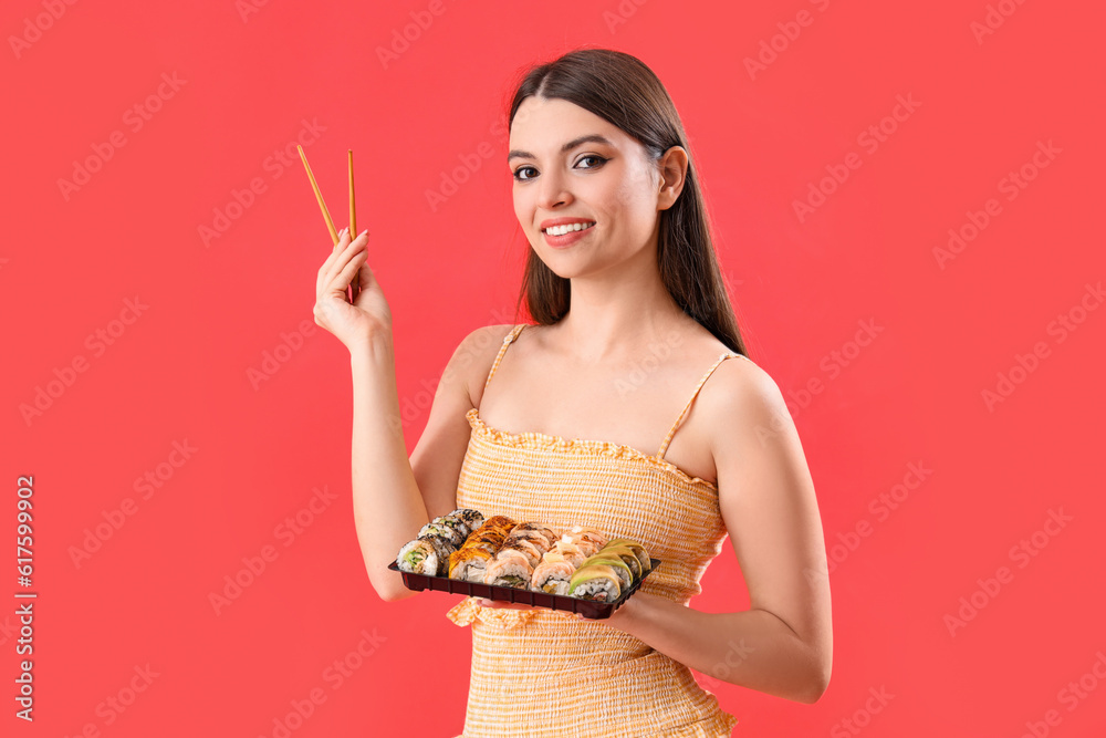 Young woman with sushi on red background